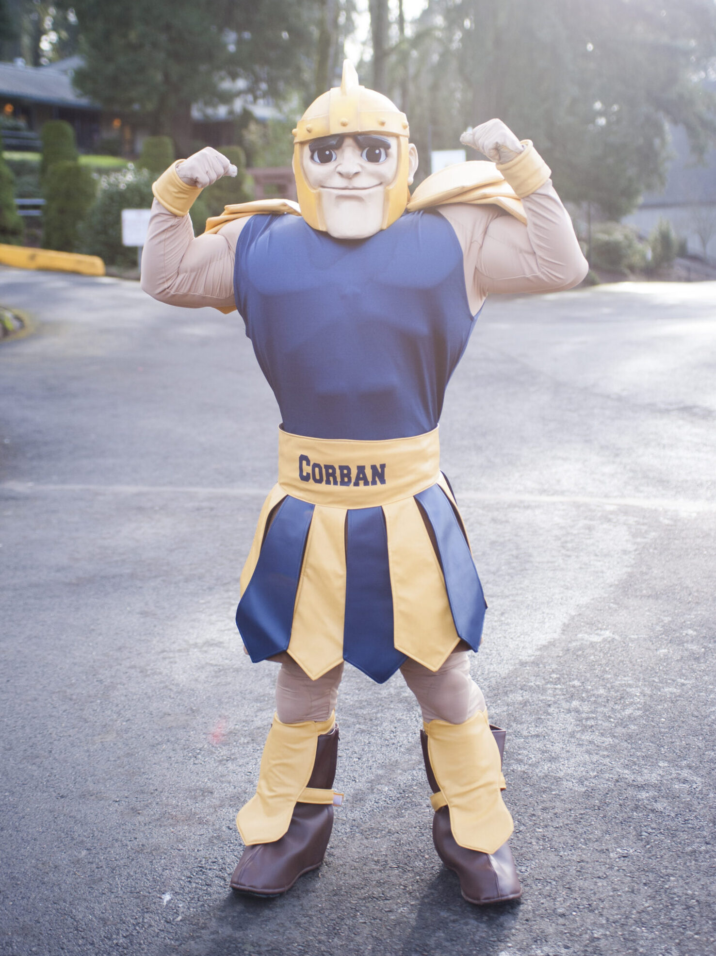Cadmar the Warrior, Corban University mascot, poses with arms flexed.