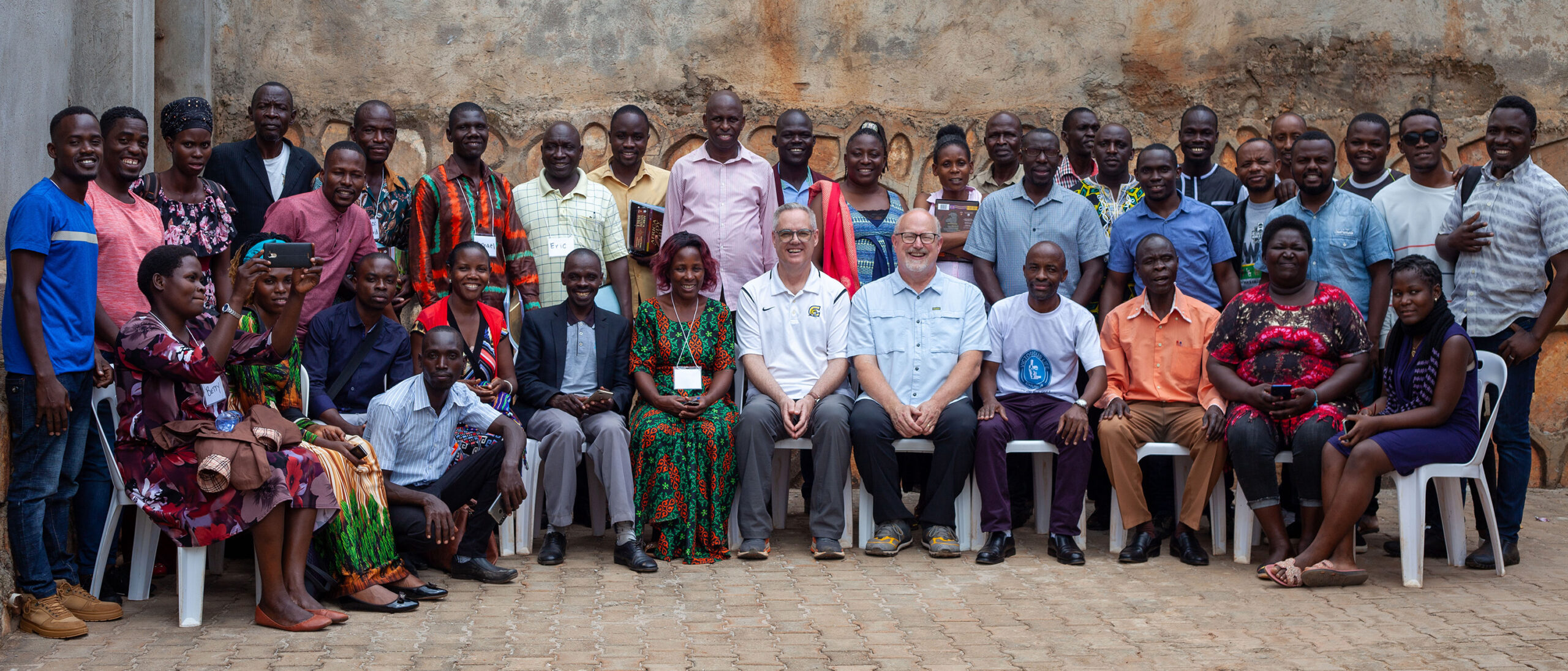 A large group of pastors pose with their instructors during a training session in Uganda.
