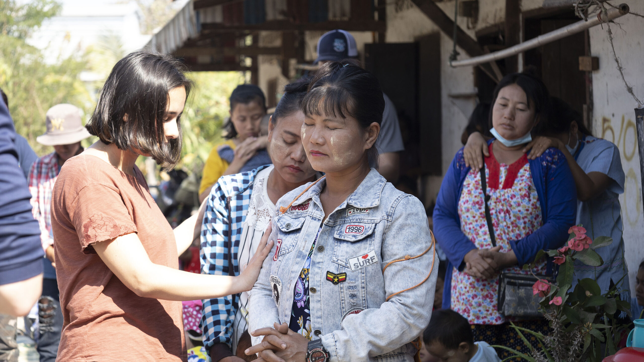 A student prays for a woman in Thailand during a mission trip.