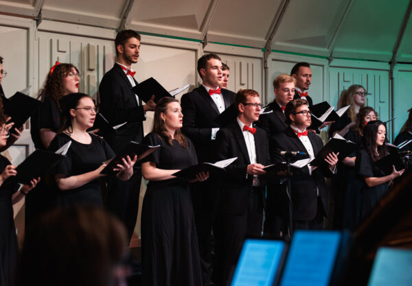 The choir sings during Christmas at Corban, captivating a large audience with their performance.