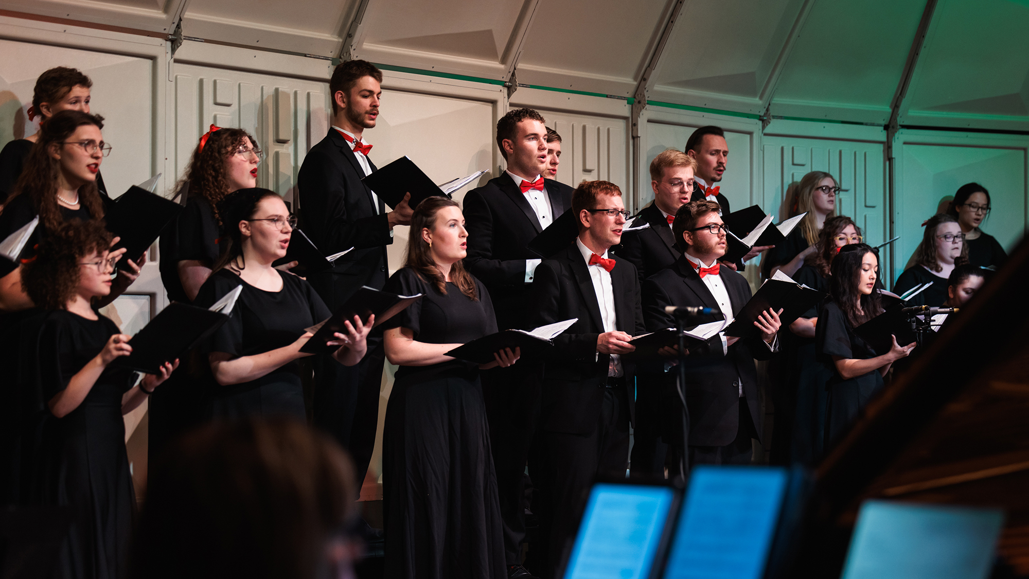 The choir sings during Christmas at Corban, captivating a large audience with their performance.