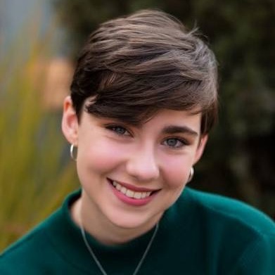 Portrait of Hannah Krantz, a young woman with short hair, dressed in a green sweater.