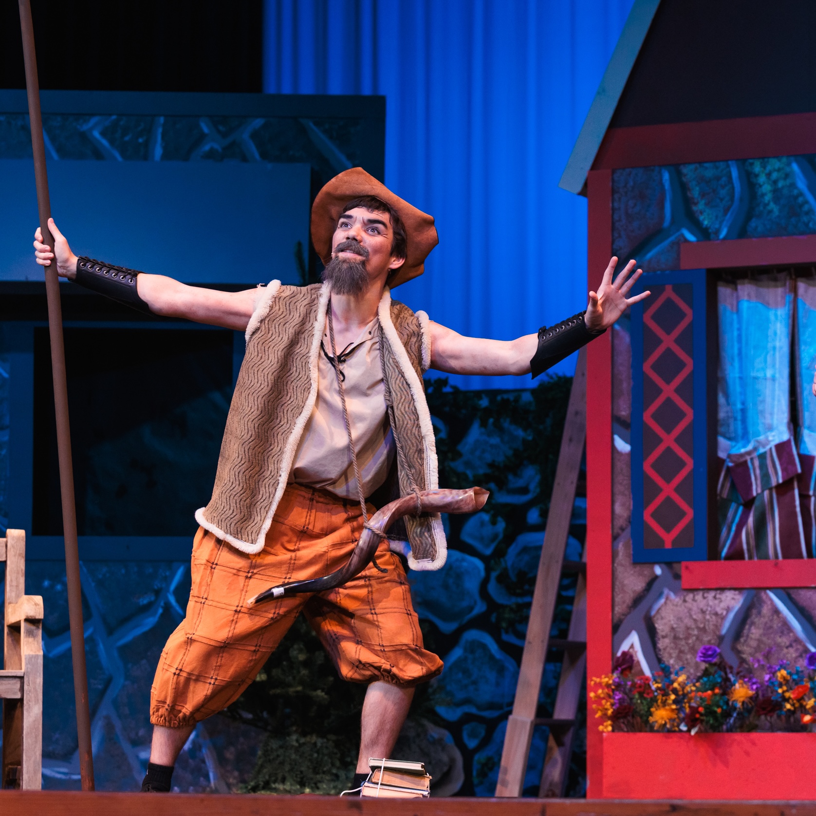 A man dressed in a theatrical costume, acting on stage in the play "Fools."