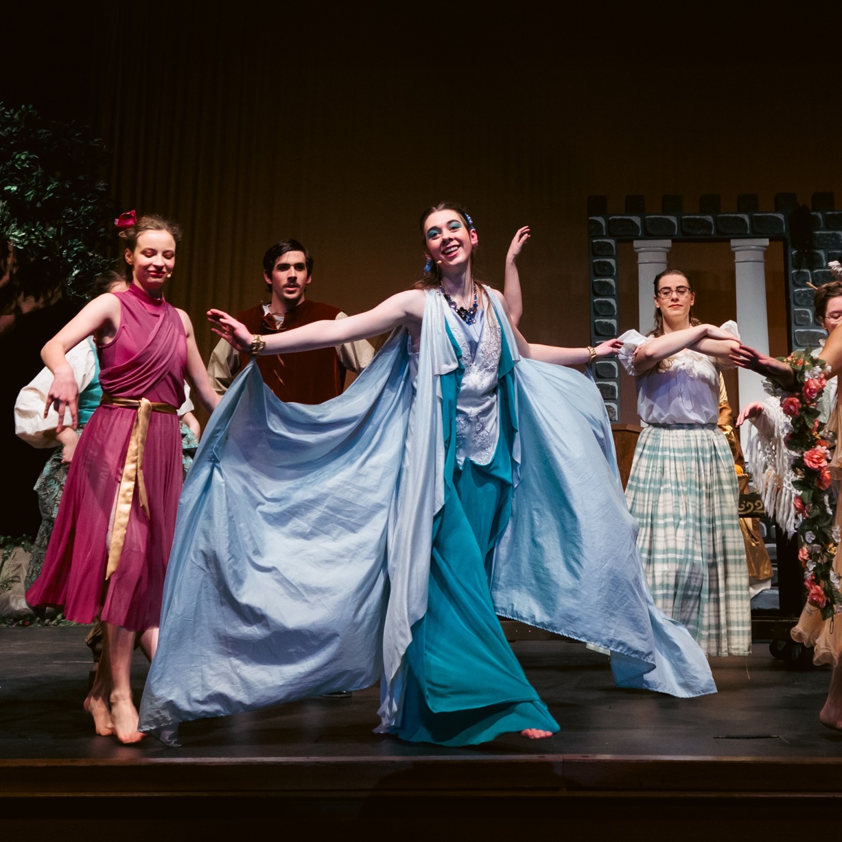 Cast members in vibrant costumes portraying characters from Sleeping Beauty, Briar Rose on stage, showcasing a lively performance.
