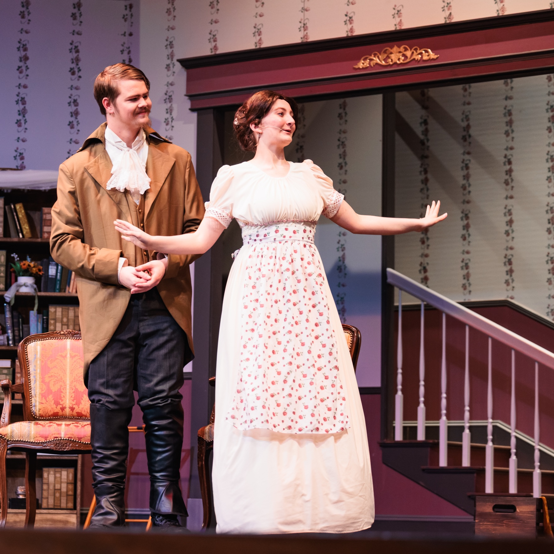 A man and woman dressed in period costumes act on stage in the production of "Good Wives."