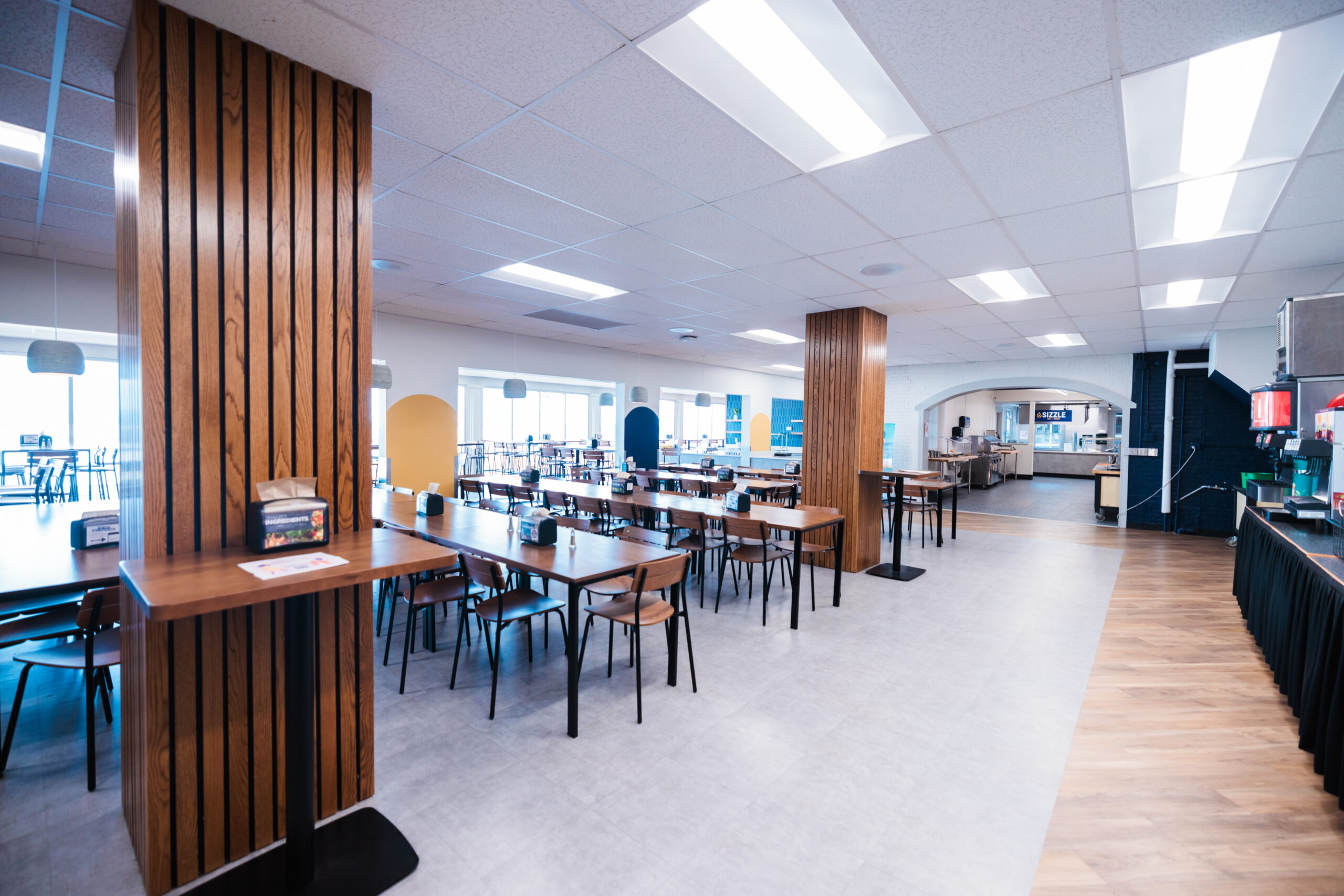 Travis Memorial Dining Hall featuring multiple tables and chairs arranged for dining.