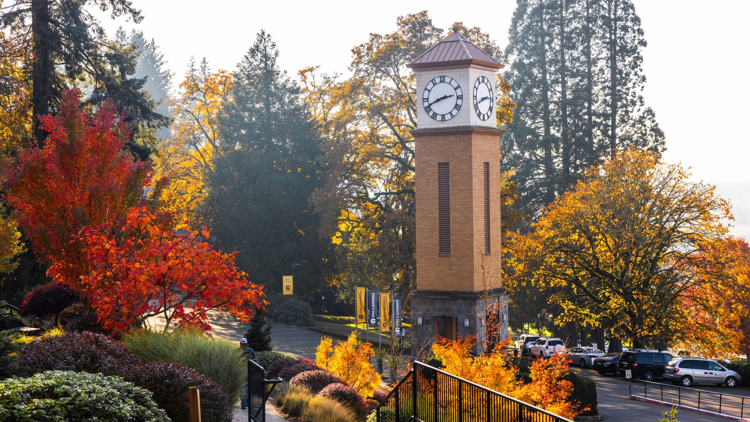 The clock tower is centrally located in Corban's campus, marking the time against a backdrop of trees.