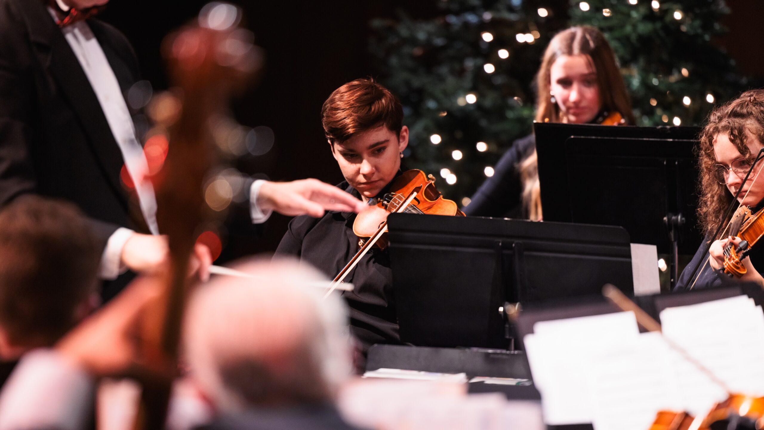 A group of musicians performing together at the "Christmas at Corban" concert, creating a festive atmosphere.