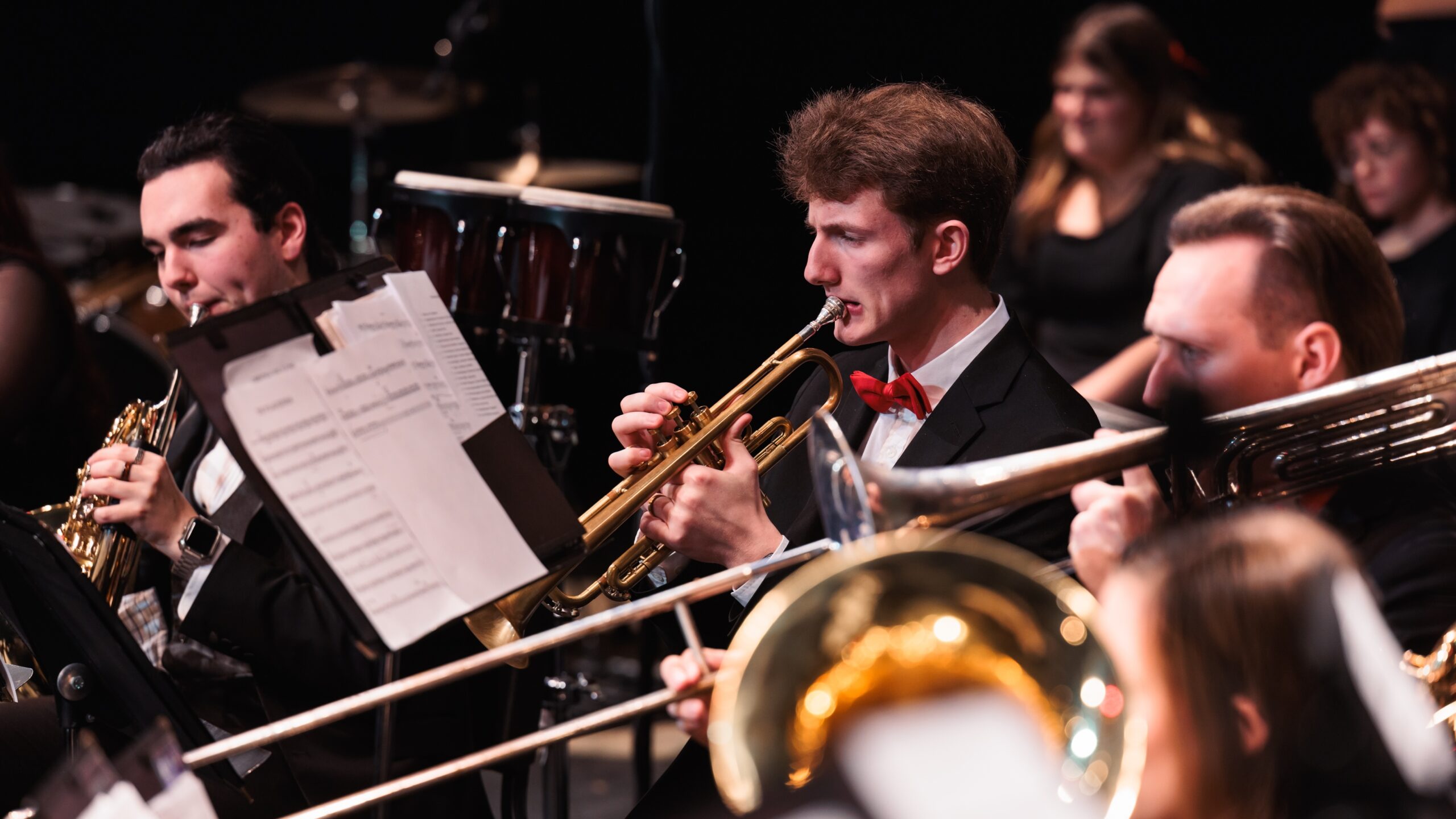 A group of musicians performing together at the "Christmas at Corban" concert, creating a festive atmosphere.