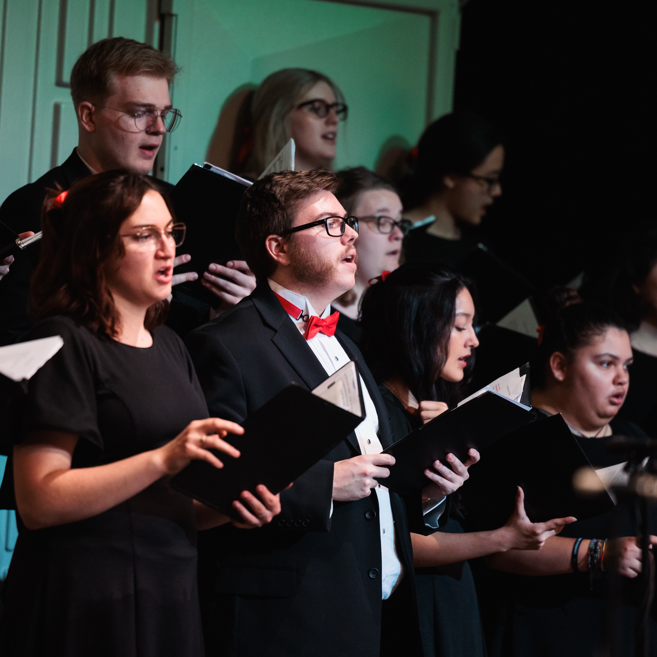 A group of students joyfully sing together in concert choir during the Christmas at Corban event.