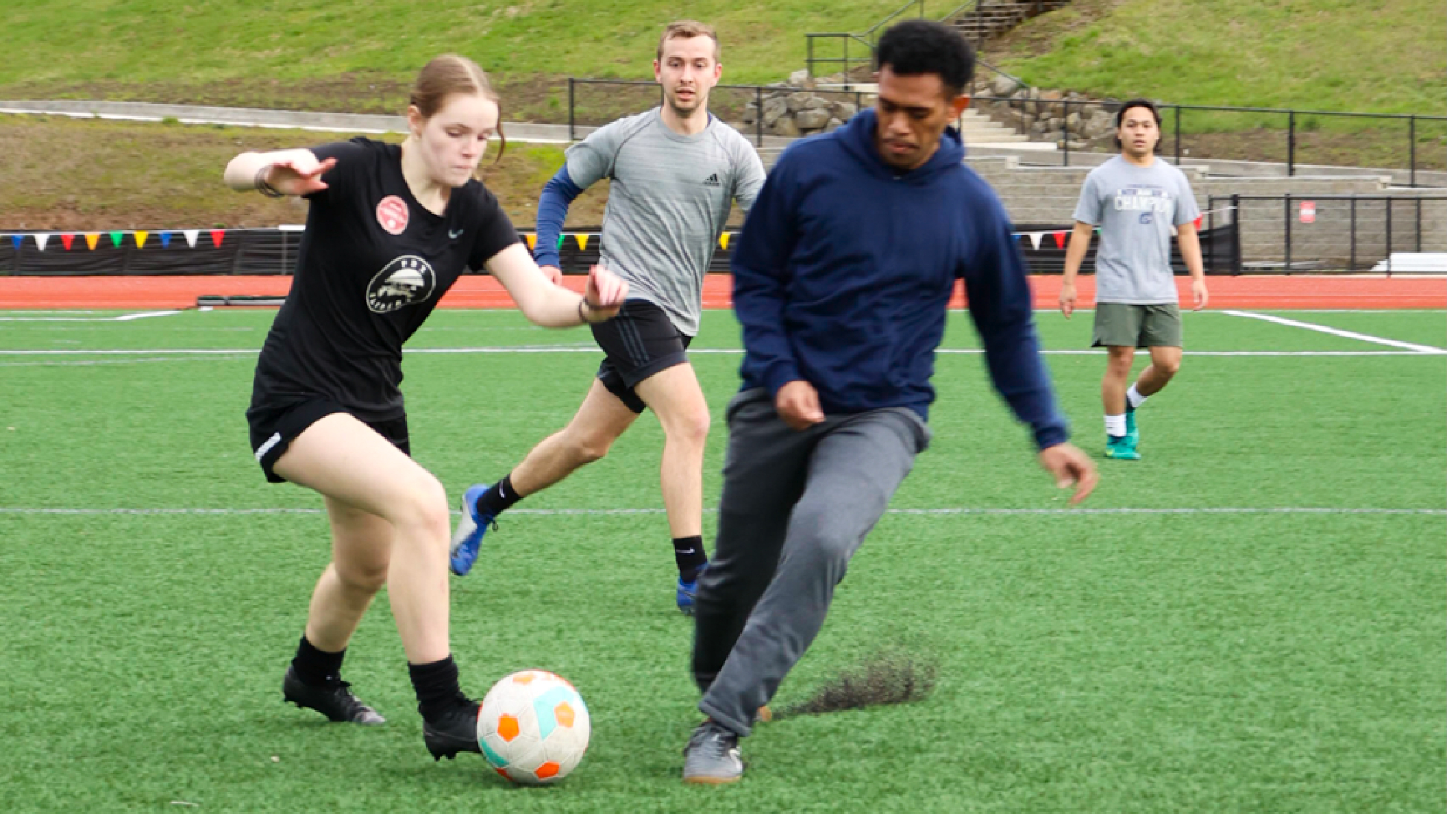 A group of students engaged in an intramural soccer game on a grassy field.
