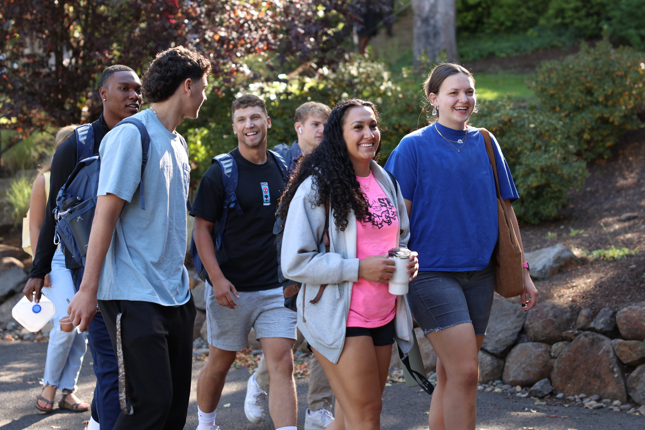 A group of college students talking and laughing together while walking to chapel
