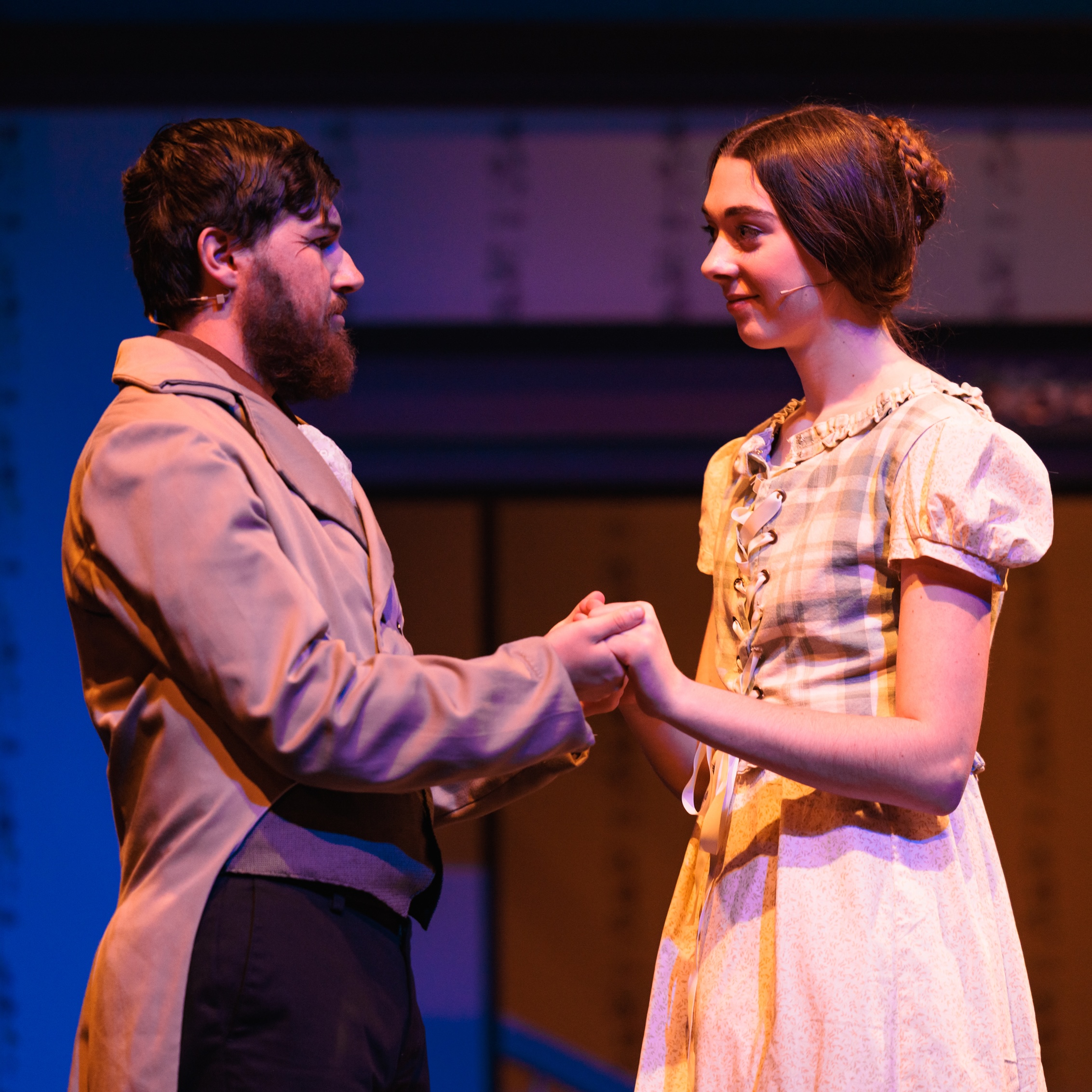 On stage, a man and woman clasp hands, portraying a moment from the play "Good Wives."