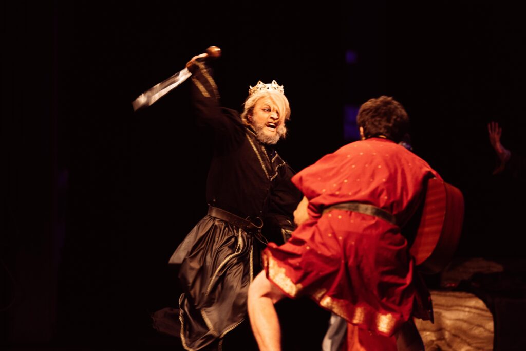 A man dressed in costume brandishes a sword, in a scene from the "Tragedy of King Saul" play.