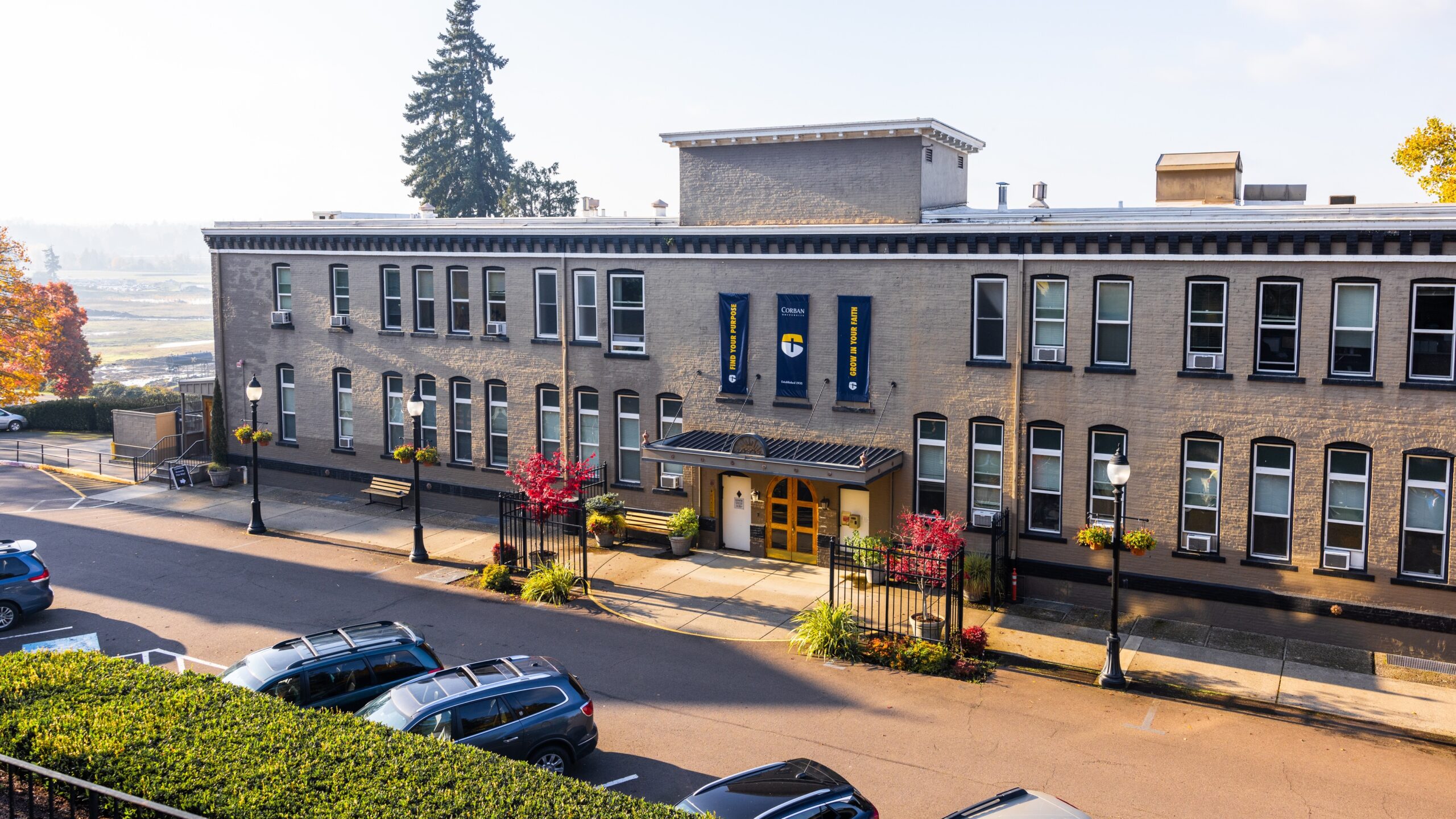 Schimmel Hall is two-story brick building with large windows, adorned with banners.