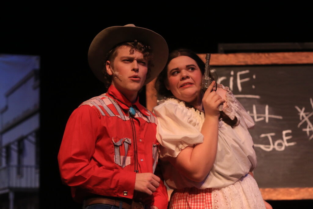 A man and woman in western outfits, representing characters from the play "Around the World in 80 Days."