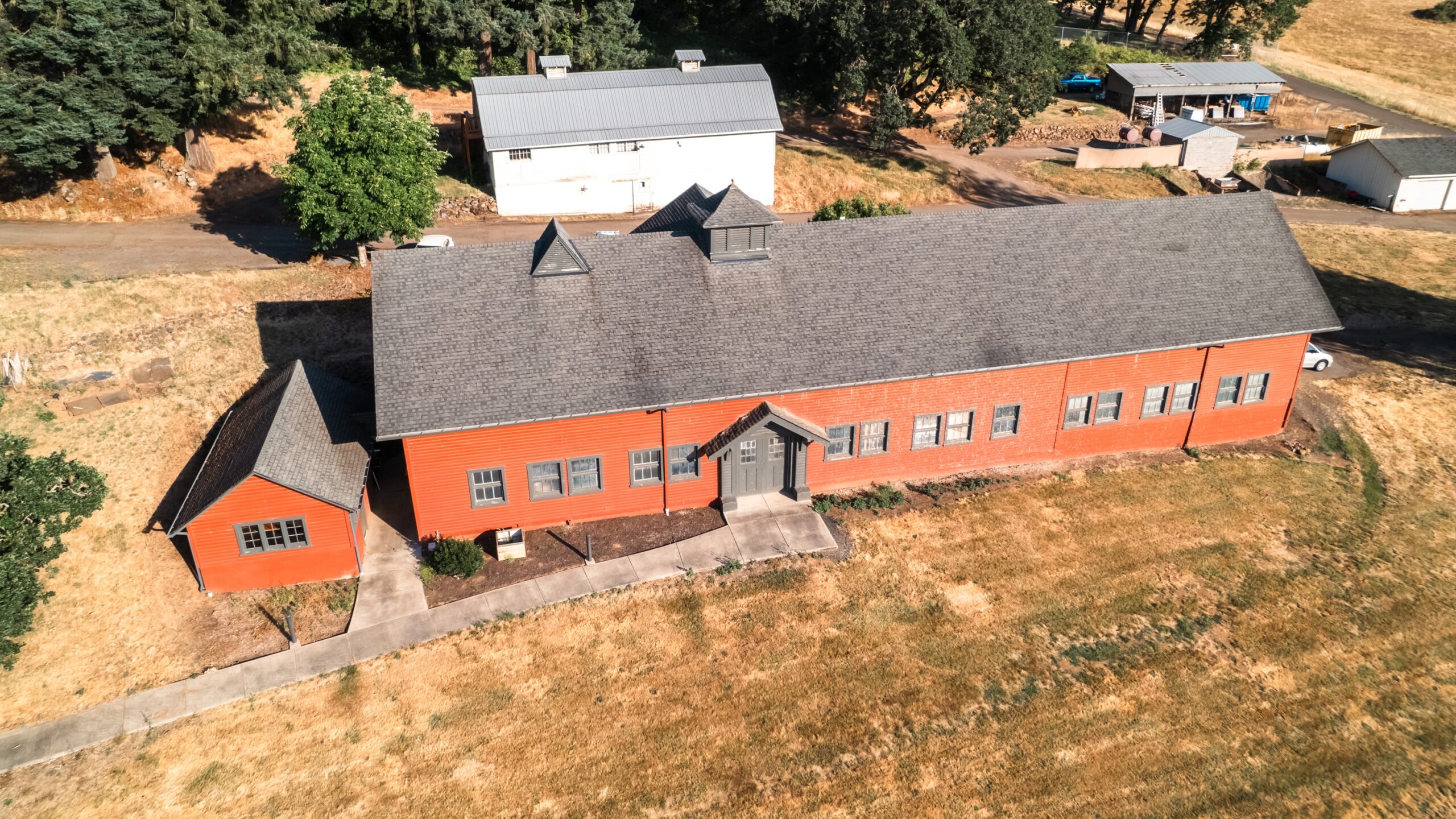 Aerial view of the Art Barn featuring red siding surrounded by a field.