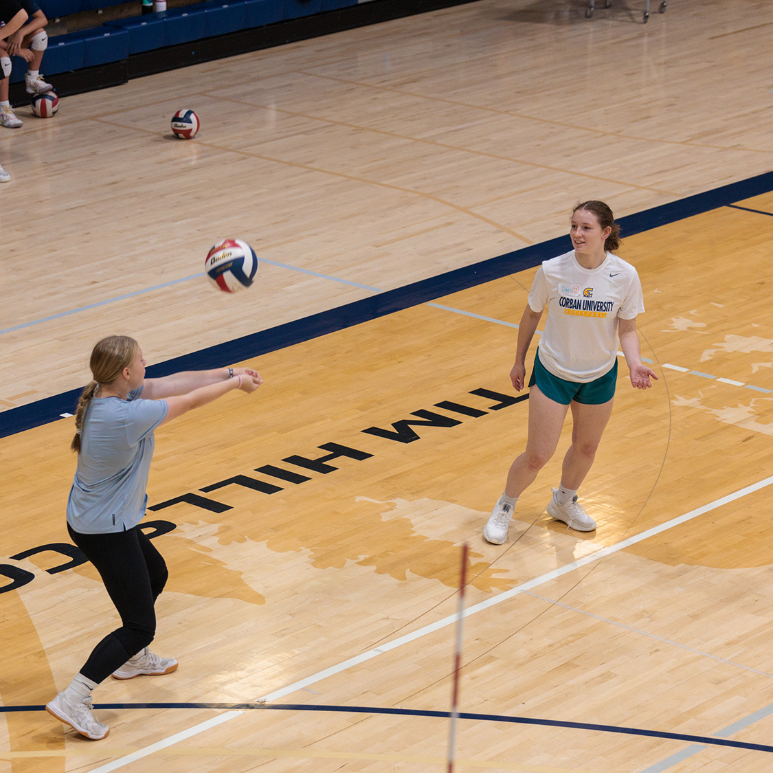 Several girls engaged in a volleyball training on a court, showcasing teamwork and athleticism.