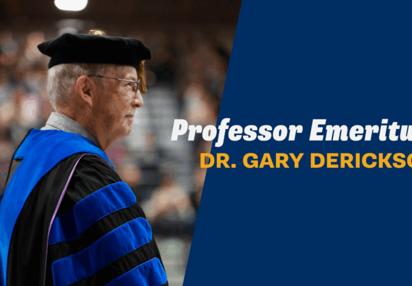 Dr. Gary Derickson in academic regalia at Corban University commencement, honored as Professor Emeritus