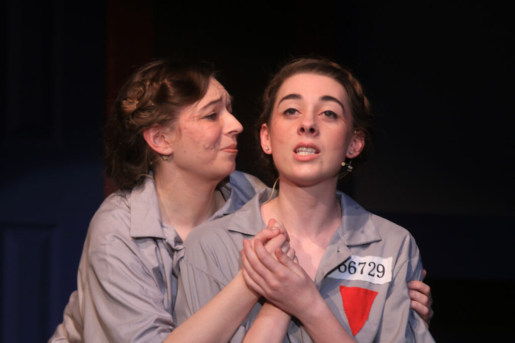 An actress portraying Corrie Ten Boom embraces her sister in the concentration camp in a scene from The Hiding Place play